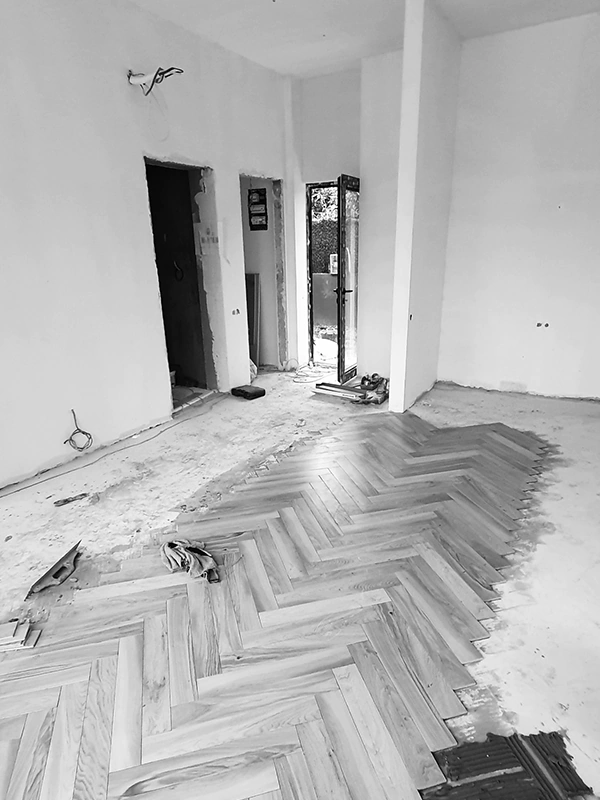 Arcus renovation in progress at Habibi, herringbone parquet being installed, plastered walls, open doorway and balcony door