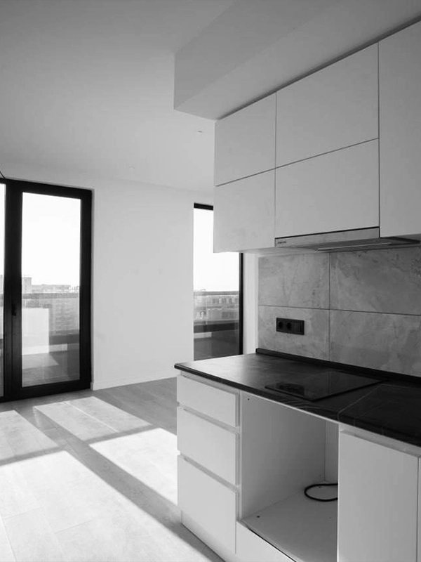 Unfurnished apartment kitchen before renovation, with natural light and bare finishes