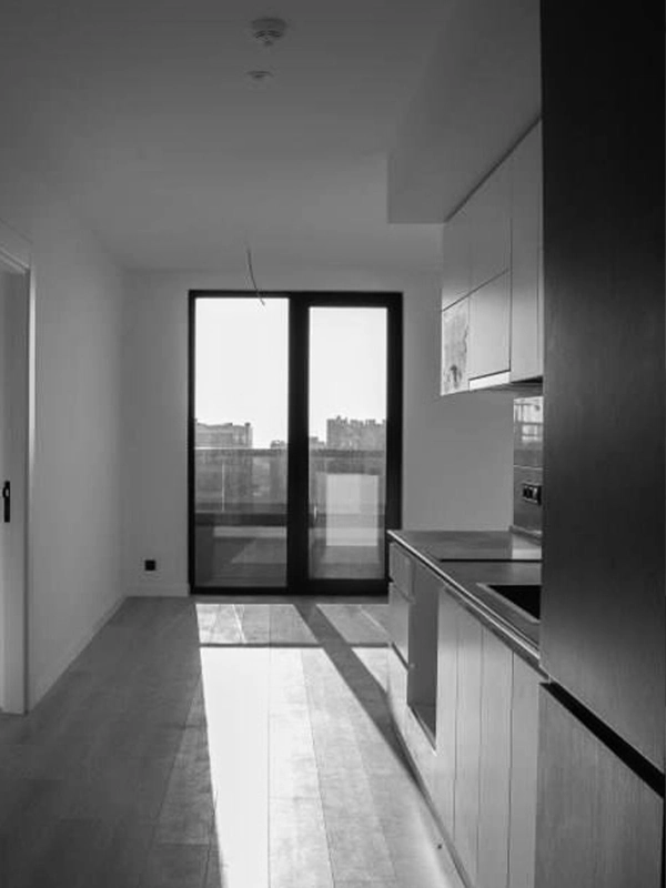 Empty galley kitchen layout before design updates, featuring basic cabinetry and no decor